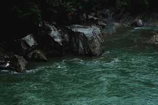 碧绿河水旁的嶙峋岩石