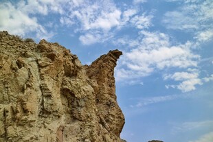 巍峨岩石耸立于蓝天白云下