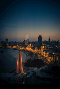 夜幕下的城市与海上帆船