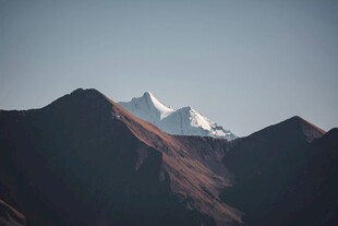 雪山映于山峦间壮丽景色