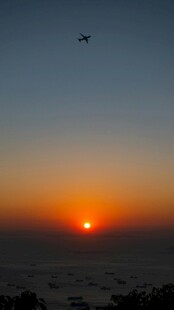 夕阳下飞机翱翔天际