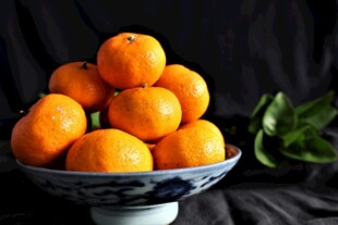 瓷碗中堆叠的新鲜橘子