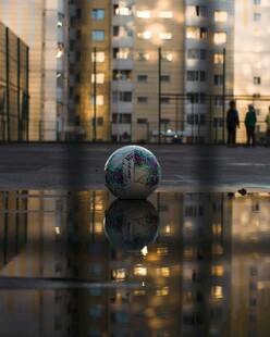 城市中球体雕塑与建筑倒影