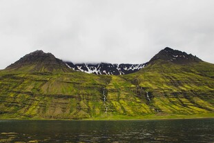 翠绿山峦间的雪山景致