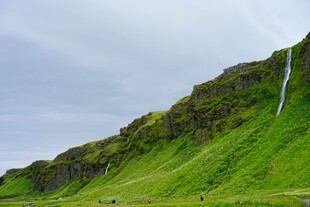冰岛翠绿山坡上的瀑布景观