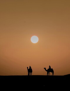 沙漠夕阳下的旅人驼影