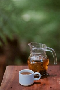 木桌上的玻璃茶壶与茶杯