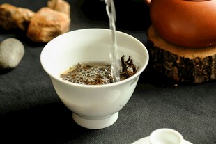 白瓷杯中的茶水正被倒入