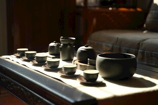 中式茶具摆放在古朴茶盘上