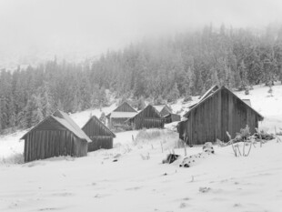 雪覆木屋的静谧山间景象
