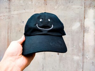 手拿笑脸图案黑色棒球帽