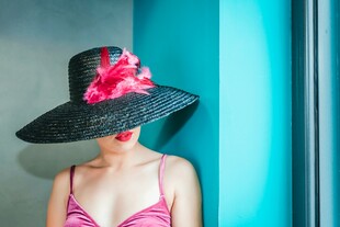 戴黑帽配粉花的时尚女性