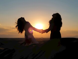 夕阳下牵手的两位女性