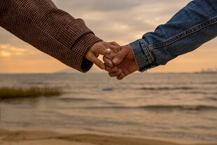 夕阳下两人海边牵手