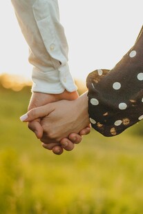 情侣牵手漫步绿意间