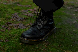 黑色马丁靴立于绿草地