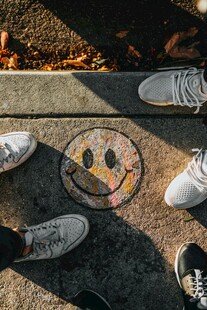 地面笑脸图案下的几双脚