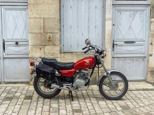 复古红摩托停靠石砌建筑旁