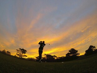 夕阳下的高尔夫挥杆瞬间
