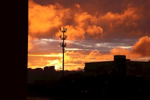 夕阳下的通信塔与城市剪影