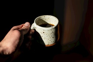 手持古朴陶瓷咖啡杯