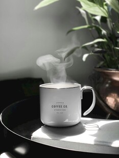 阳光下热气腾腾的白色马克杯