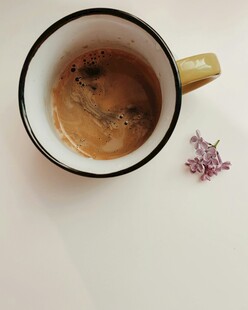咖啡杯旁的紫色小花