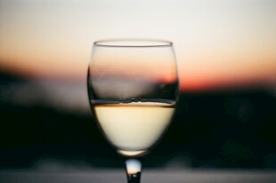 夕阳下的高脚杯白葡萄酒
