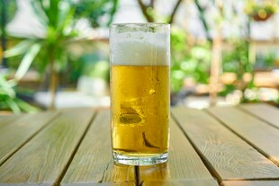 木桌上的一杯泡沫啤酒