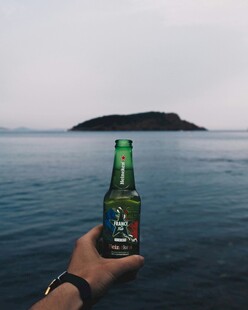 海边手持啤酒眺望小岛