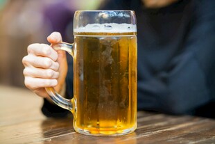 手持大杯金黄啤酒