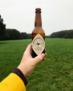 户外手持啤酒瓶惬意瞬间