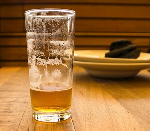 木桌上的一杯泡沫啤酒
