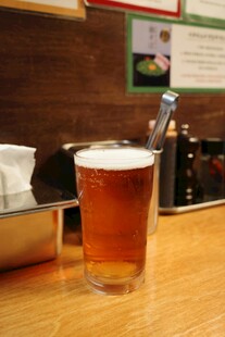 木桌上的一杯泡沫啤酒