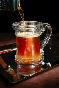 琥珀色啤酒正倒入玻璃杯中