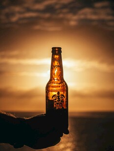 夕阳下手持啤酒瓶瞬间