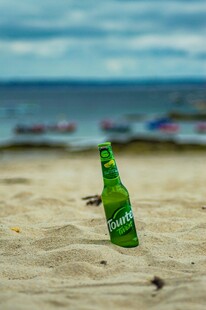 沙滩上的绿色啤酒瓶