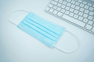 电脑旁的医用蓝色口罩