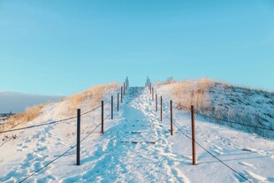 雪覆山坡的围栏小径