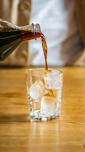 可乐倒入加冰玻璃杯