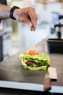 厨师为汉堡撒调料