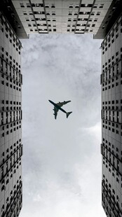 高楼间翱翔的飞机