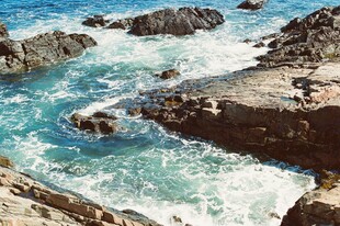 海边礁石与涌动的蓝色海浪