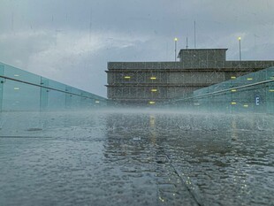 雨中玻璃建筑前的积水景象