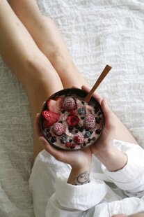 手持碗中美味浆果燕麦