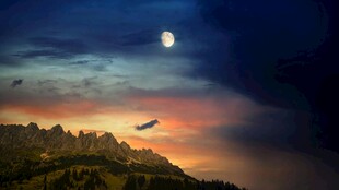 黄昏月夜下的飞鸟与山峦