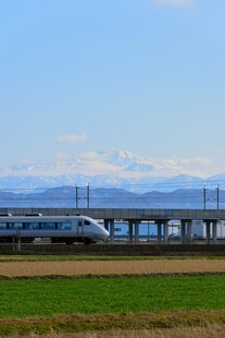 高铁穿行于田野与远山间