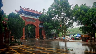 中式牌坊下的雨后街景