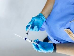 医护人员手持注射器准备注射