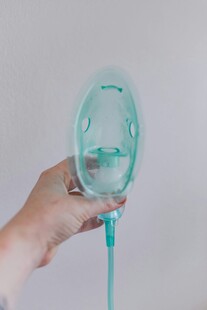 手持浅绿色医疗氧气面罩